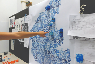 A critique class with 3d printed parts on the wall. 