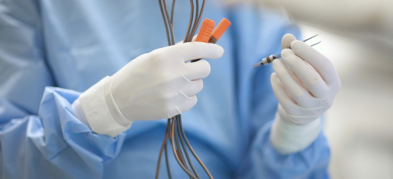 Doctor with gloved hands holding medical device