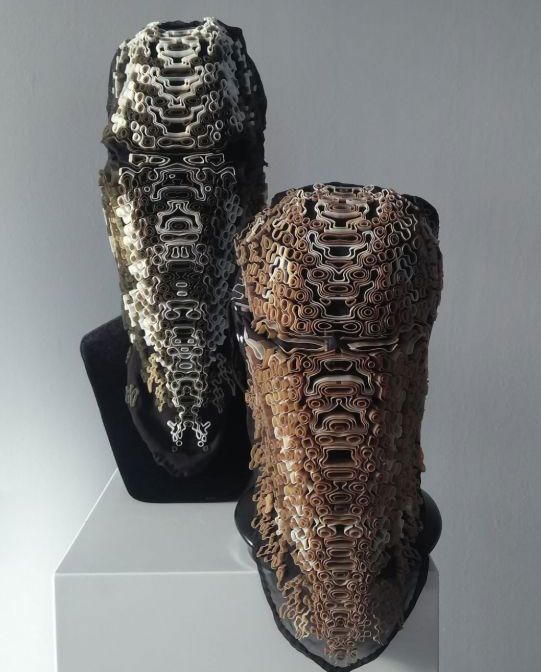 Two 3D printed mask art on stand