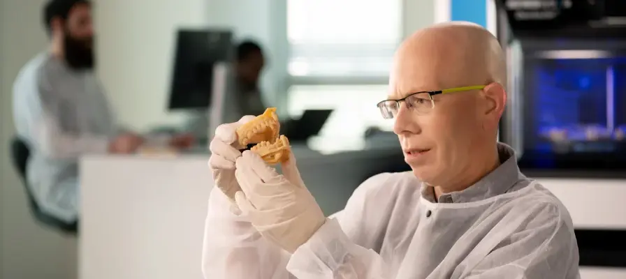 dental-technician-examining-3d-printed-denture-model