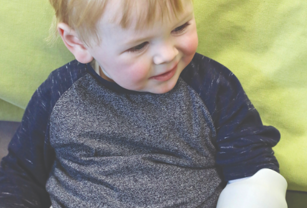 Child pictured with 3D printed arm. 