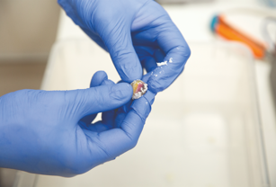 Hands holding a newly 3D printed pebble. 