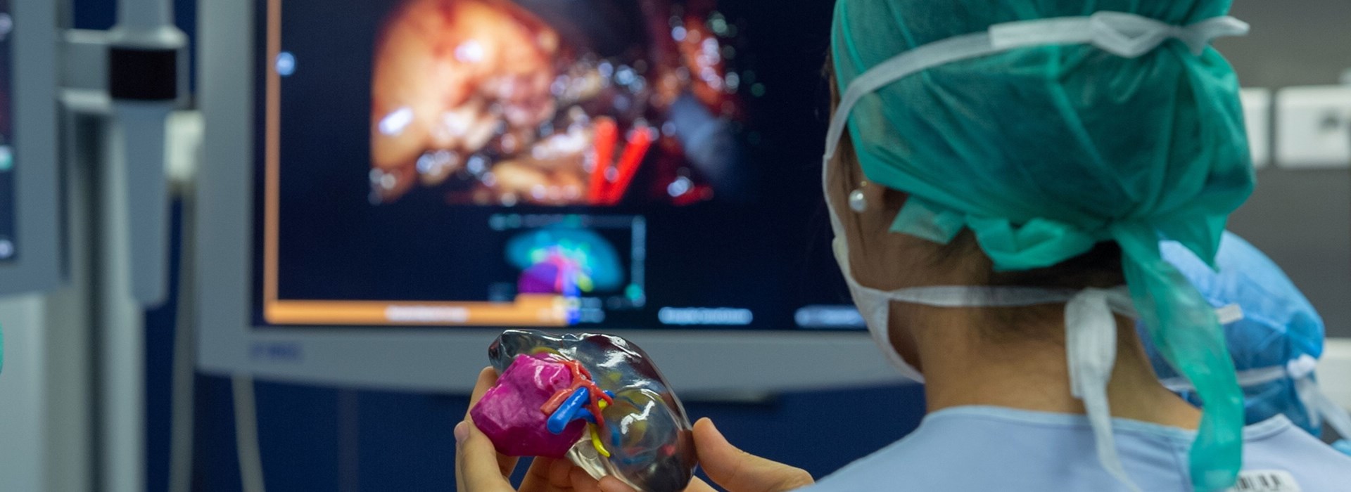 Trainee surgeon using a 3D printed model of a patient’s kidney in the operating theatre during a surgery.