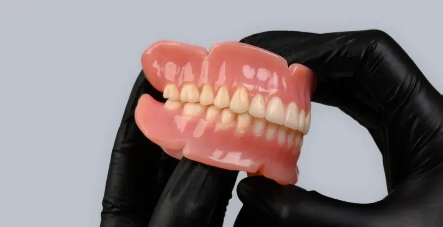 black-gloved-hands-holding-truedent-denture