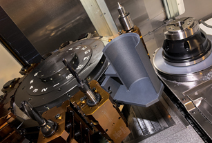 The 3D printed part catcher (gray) is attached to the lathe’s lower turret.